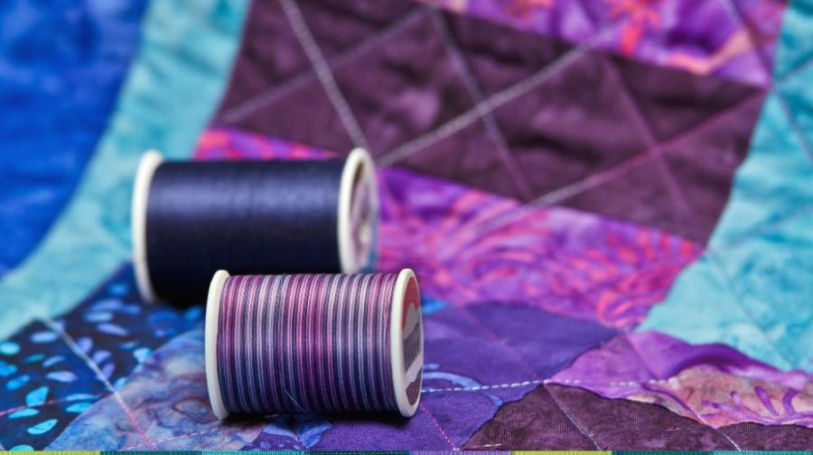 spools of thread and quilt