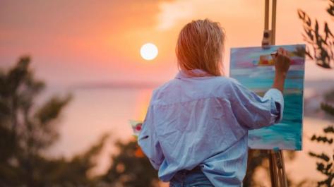 girl painting a sunset